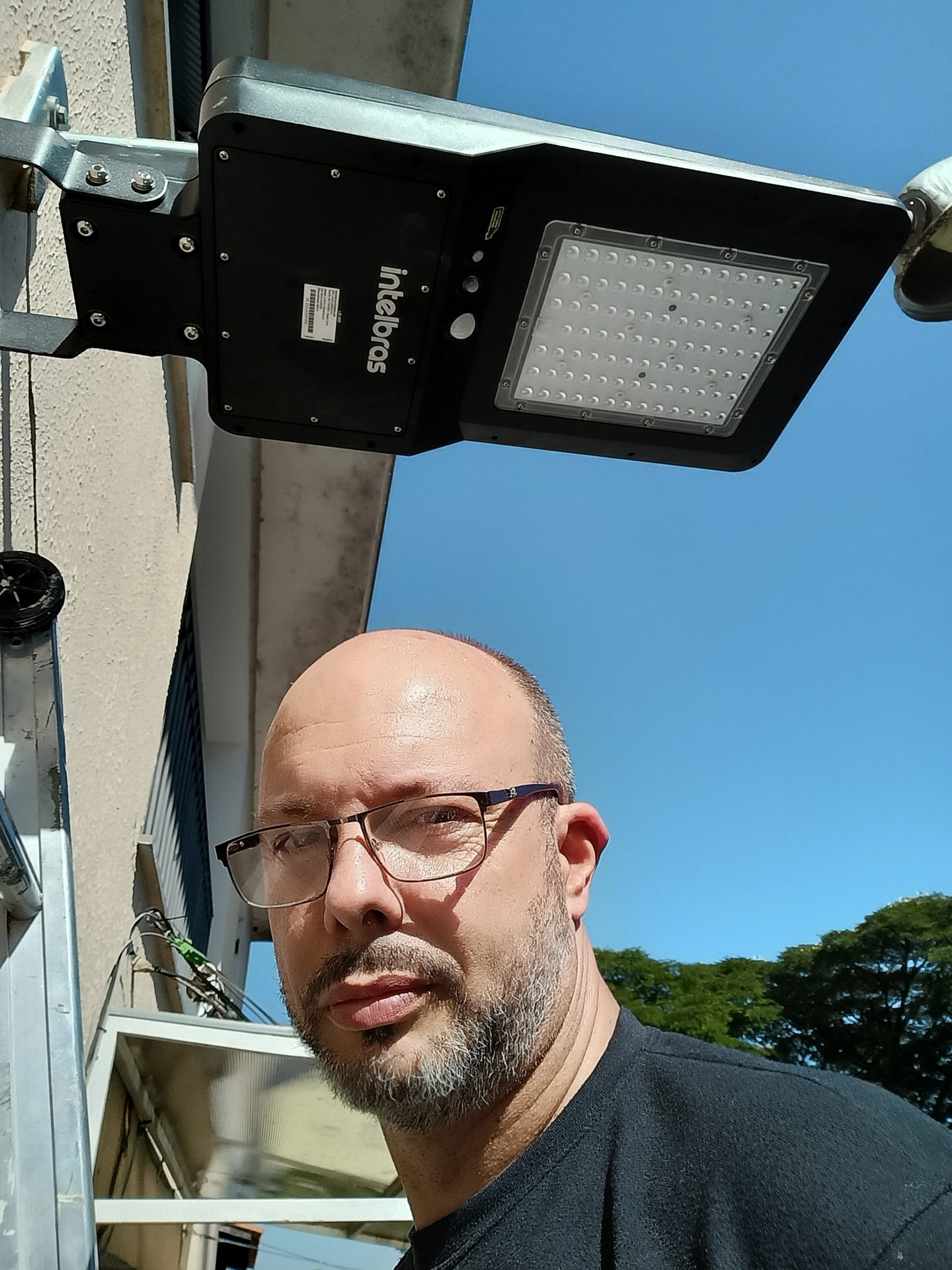 Marcos, fundador da Infomode, instalando luminária solar Intelbras